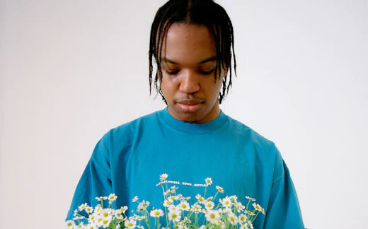 Man in blue shirt looking down at bouquet of flowers Phoenix - Futures - Ripple+